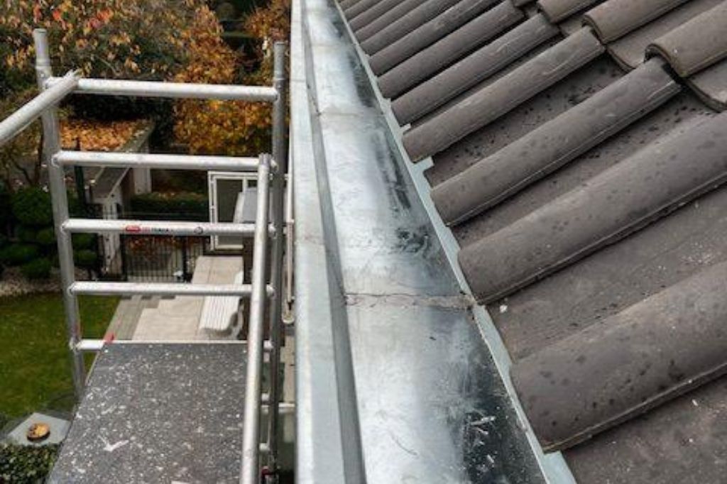 Dakgoot en steiger naast pannendak