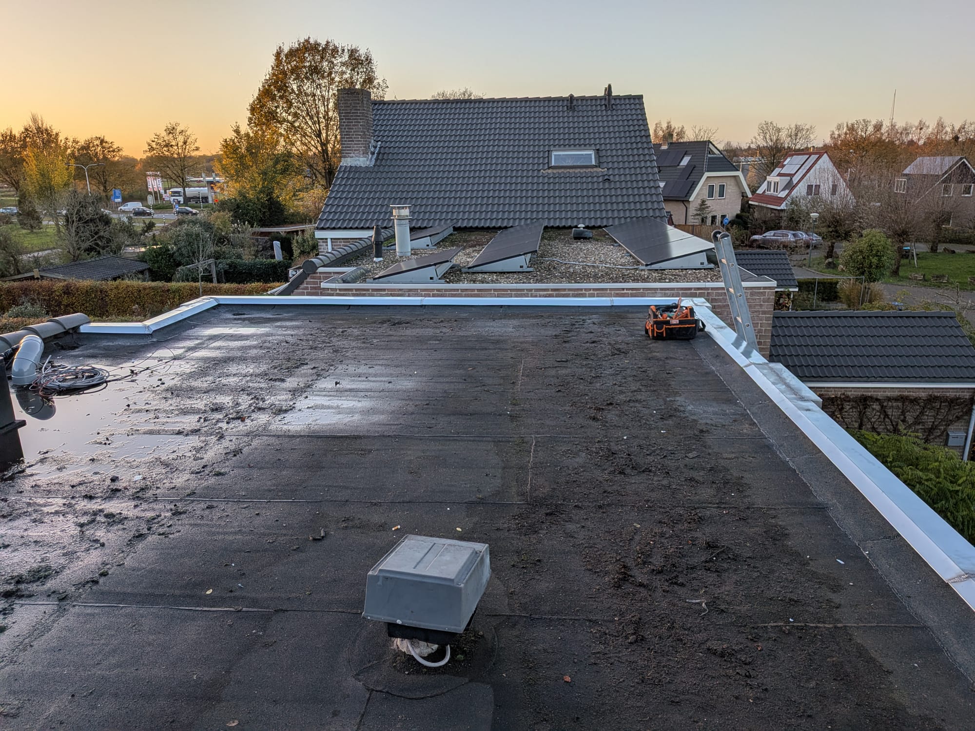 Plat dak met zonnepanelen bij zonsondergang