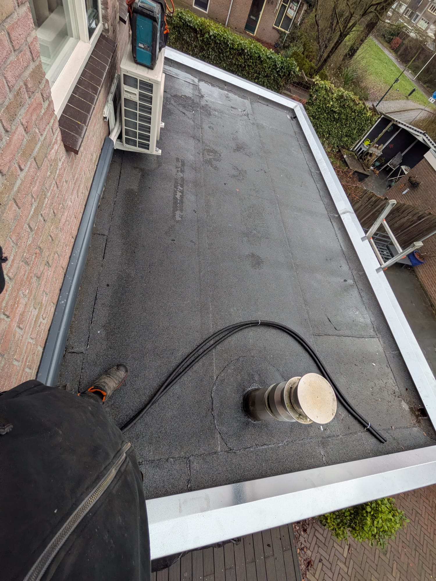 Plat dak met airco en ventilatiepijp.
